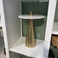 Decorative gold cone on a white shelf with a blurred background