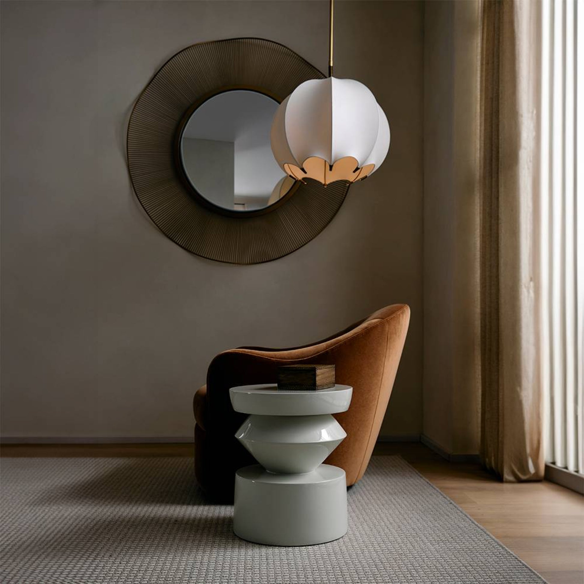Modern interior with a round mirror, pendant light, and chair.