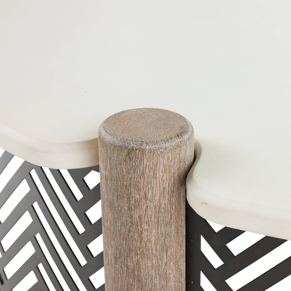 Close-up of a wooden stool with a white cushioned seat on a geometric patterned floor.