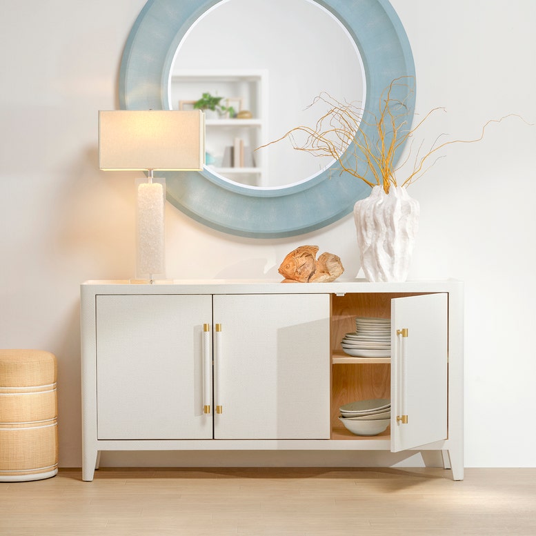 White sideboard with open doors displaying plates, a lamp, and decorative items in a room.