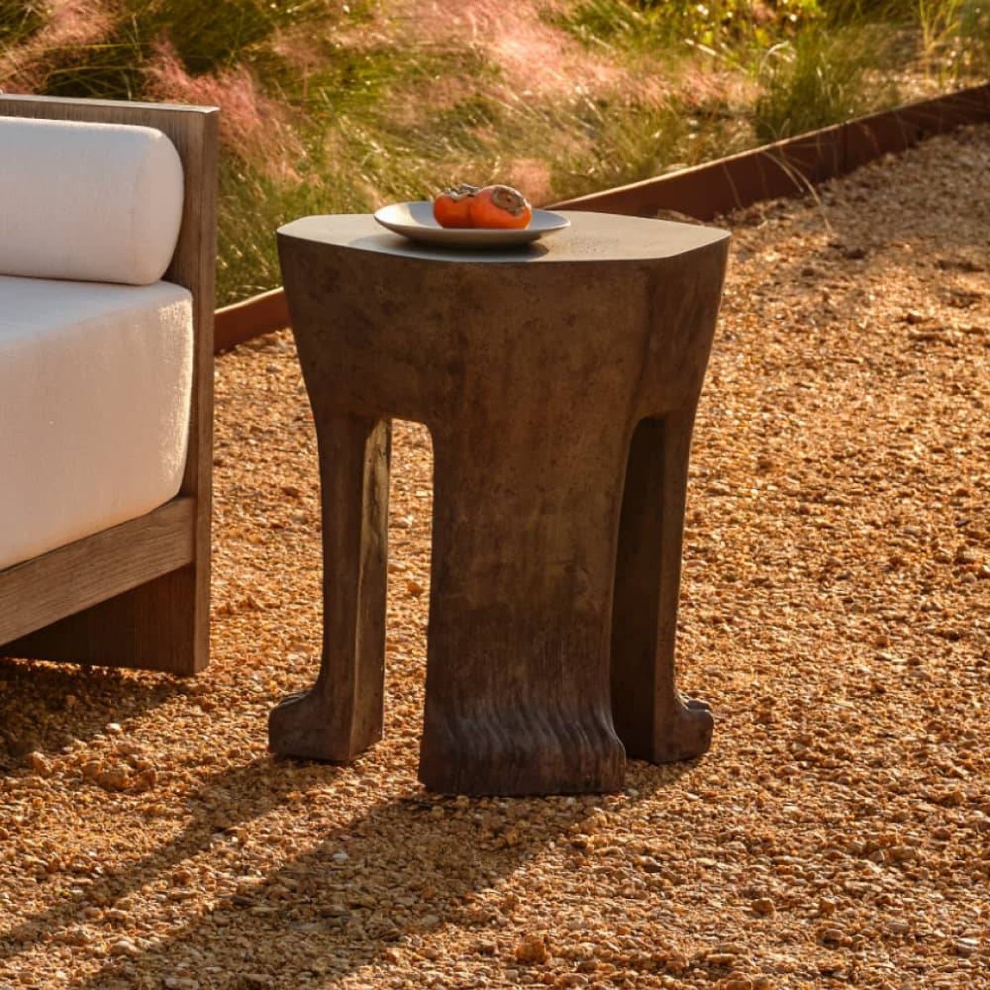 Concrete side table with a plate of food on a gravel surface