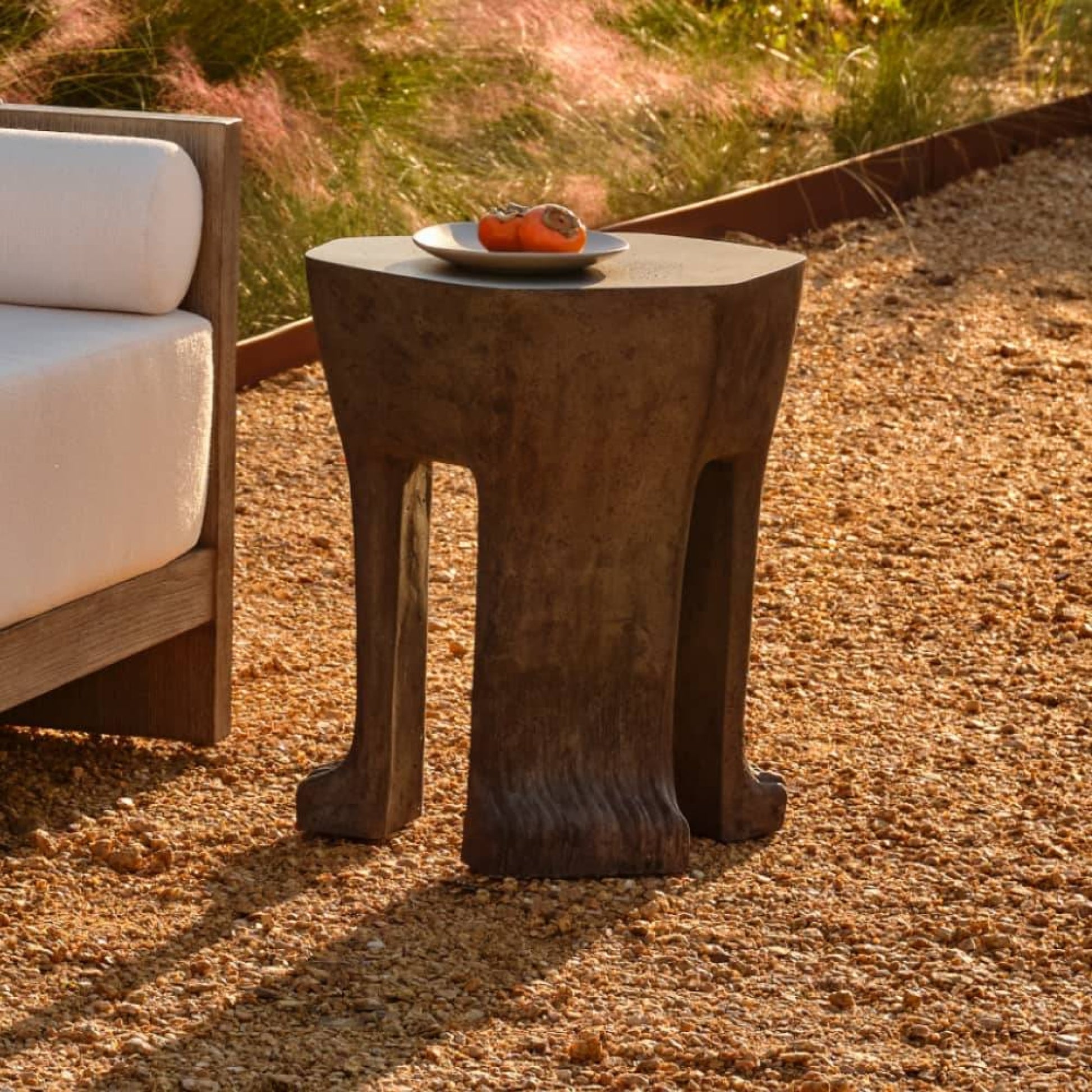 Concrete side table with a plate of food on a gravel surface