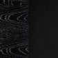 Close-up of a black textured material sample with a vertical split: left side shows a dark wood grain pattern, right side shows a smooth black pebbled texture.