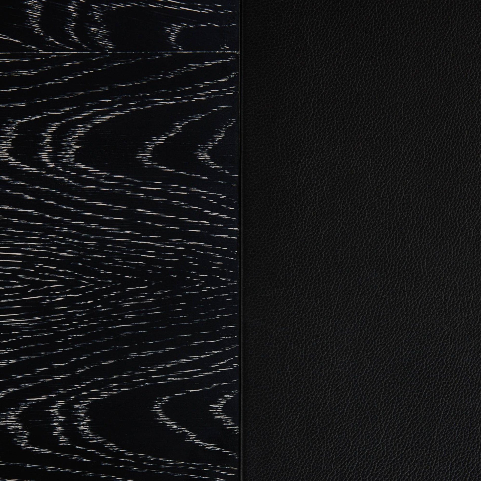 Close-up of a black textured material sample with a vertical split: left side shows a dark wood grain pattern, right side shows a smooth black pebbled texture.