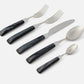 Set of silverware with black handles on a white background