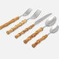 Five-piece flatware set with polished silver metal heads and warm brown wooden bamboo handles