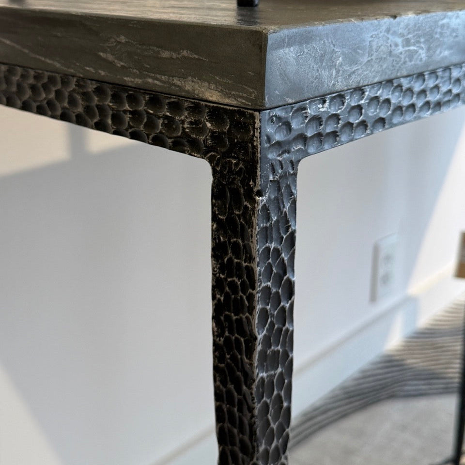 Close-up of a textured black metal table with a blurred background
