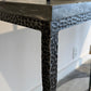 Close-up of a textured black metal table with a blurred background