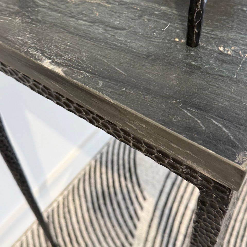 Close-up of a black metal shelf with a textured surface