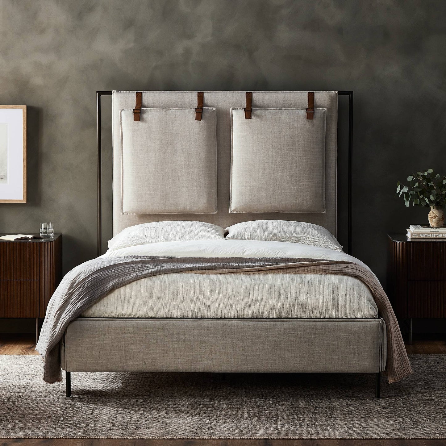 Beige upholstered bed with wooden headboard in a bedroom setting