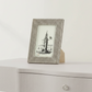 Small photo frame with a lighthouse picture on a white surface