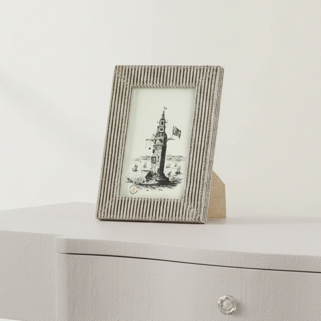 Small photo frame with a lighthouse picture on a white surface
