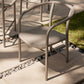 Beige outdoor chair on a patio with grass and stones in the background