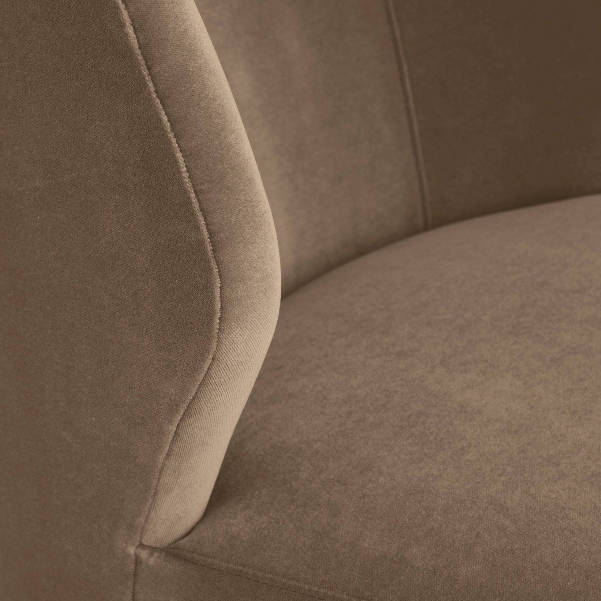 Close-up of a brown upholstered chair with visible stitching