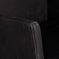 Close-up of a dark gray upholstered chair corner on a black background