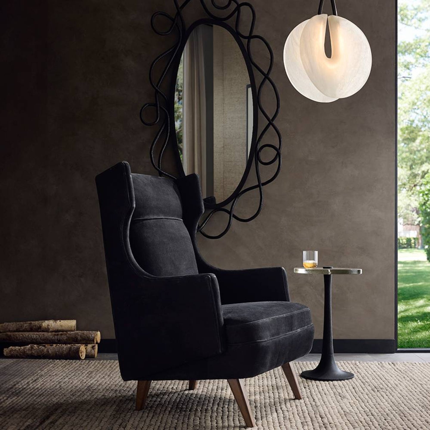 Modern interior with a dark gray armchair, decorative mirror, and small table.
