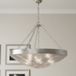Silver pendant light hanging from a ceiling with framed pictures on the wall.