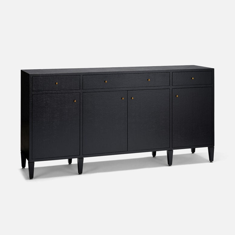 A modern black sideboard cabinet with three drawers on top, two doors in the center, and four tapered legs, accented with small brass knobs, shown on a light gray background.