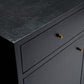 Close-up of a dark charcoal textured cabinet with two drawers and two small round metallic knobs, shown against a black background.