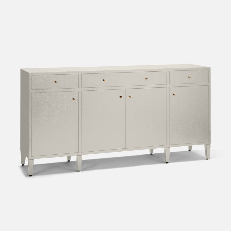 A modern sideboard cabinet with a textured light beige linen finish, featuring three drawers on top, two doors in the center, and four tapered legs, accented with small round gold knobs.