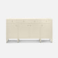 An off-white linen-textured sideboard with five drawers and doors, accented by small round brass knobs and supported by tapered legs, shown against a light gray background.