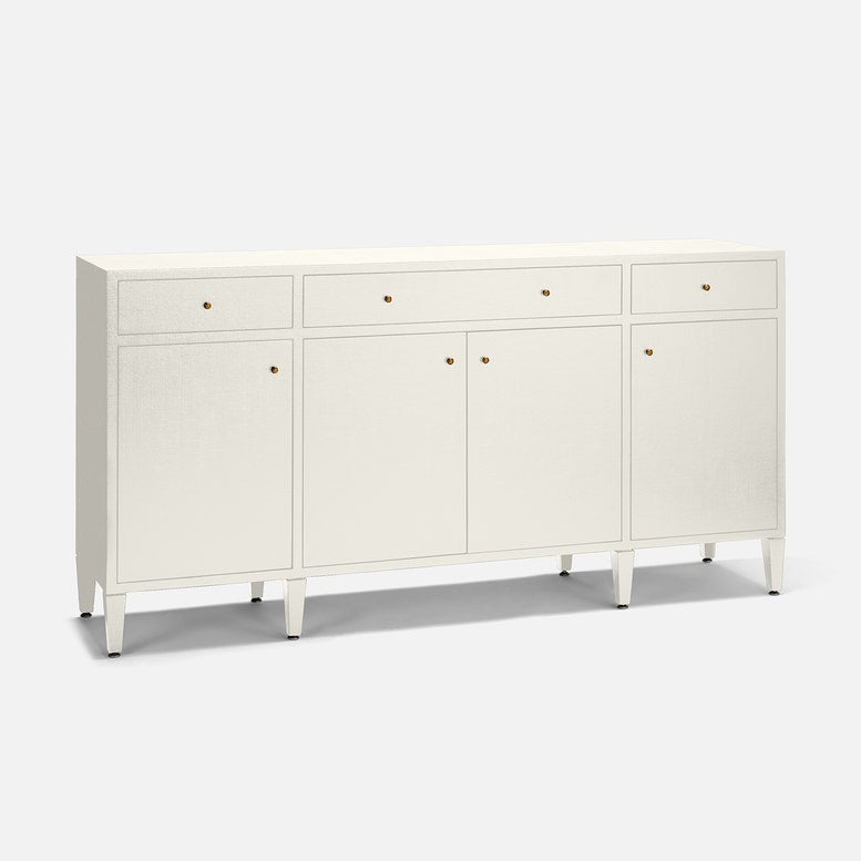 An off-white wooden sideboard cabinet with three drawers on top, two doors in the center, and three doors on the right, accented with small round gold knobs and supported by tapered legs, shown on a light gray background.