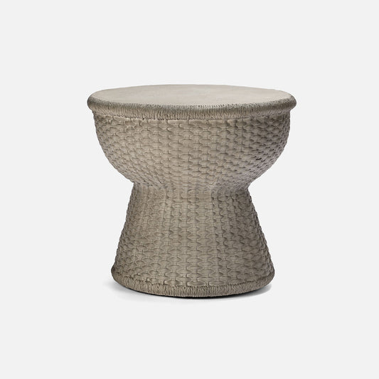 Woven side table with a beige cushion on a white background