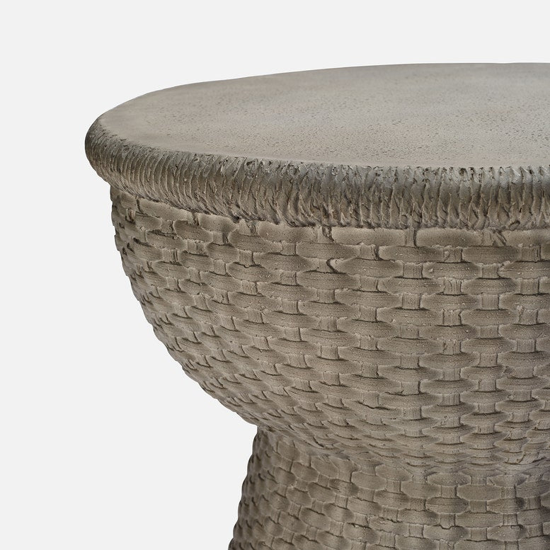 Close-up of a textured round stool on a light gray background