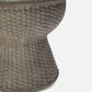Close-up of a textured woven stool on a light gray background