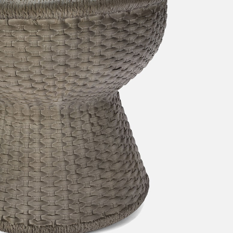 Close-up of a textured woven stool on a light gray background