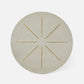Round beige placemat with gold starburst design on a white background