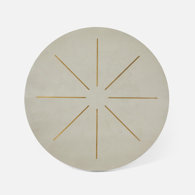Round beige placemat with gold starburst design on a white background