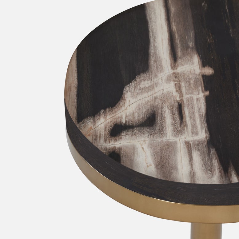Round side table with dark marble-like top and gold base on a white background