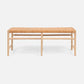 Wooden bench with woven seat on a white background