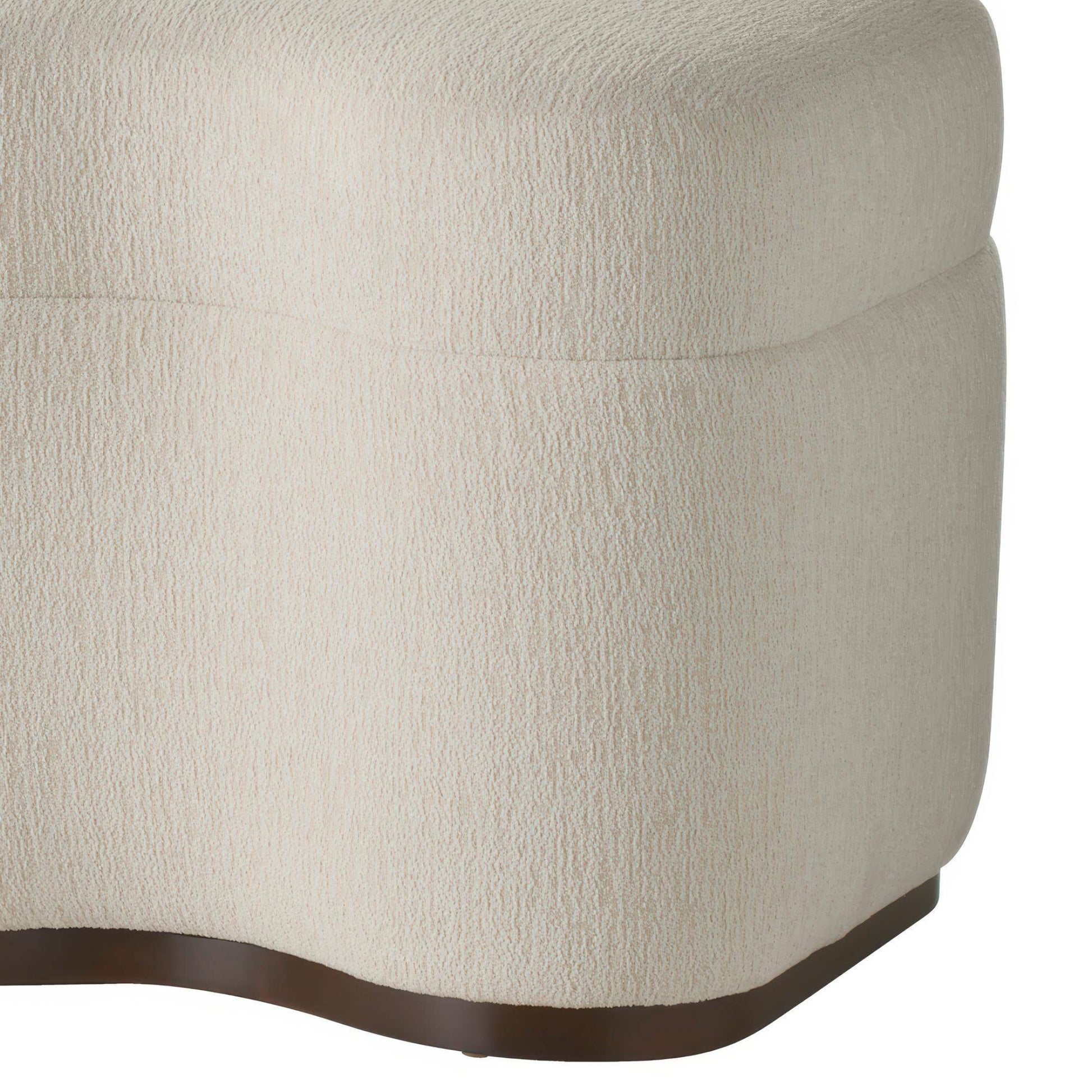 Close-up of a textured beige ottoman with a brown trim on a white background