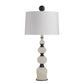 Decorative table lamp with a white shade and black and white base on a white background