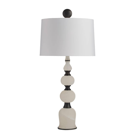 Decorative table lamp with a white shade and black and white base on a white background