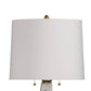 Table lamp with a white shade and gold accents on a white background