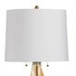 Table lamp with a white shade and gold base on a white background