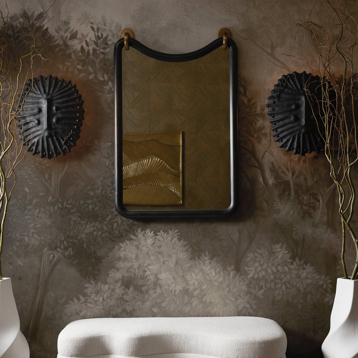 Decorative mirror with black frame on a textured wall with floral patterns