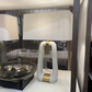 Two lamps on a display table with a reflective surface in the background