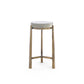 A modern accent table with a round white top and a textured, woven metallic gold base, shown against a plain white background.