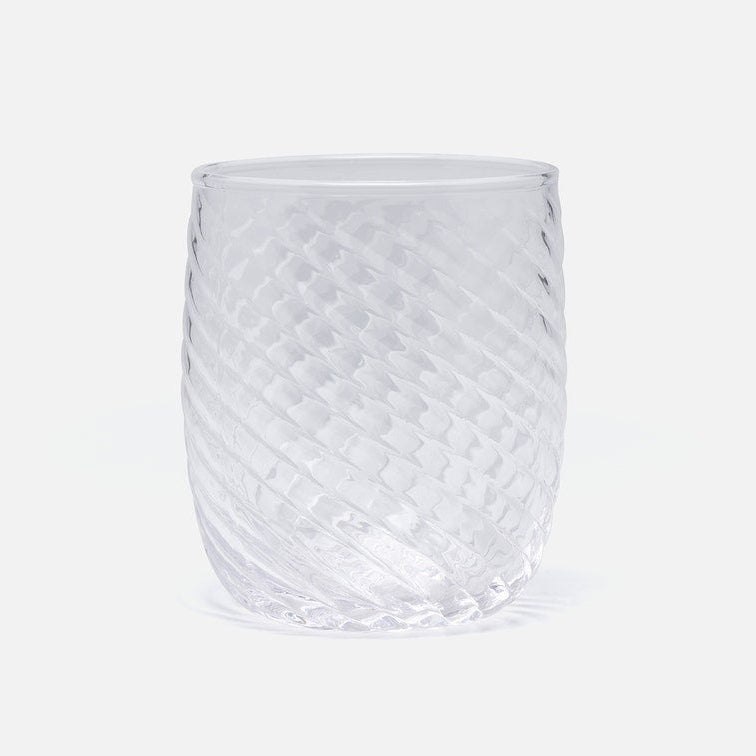A clear textured glass tumbler with a diamond-patterned surface and diagonal ribbed sides, shown on a light gray background.