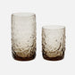 Two textured glass tumblers on a white background