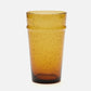 An amber-colored translucent glass tumbler with a speckled texture and a flared rim, shown against a plain white background.