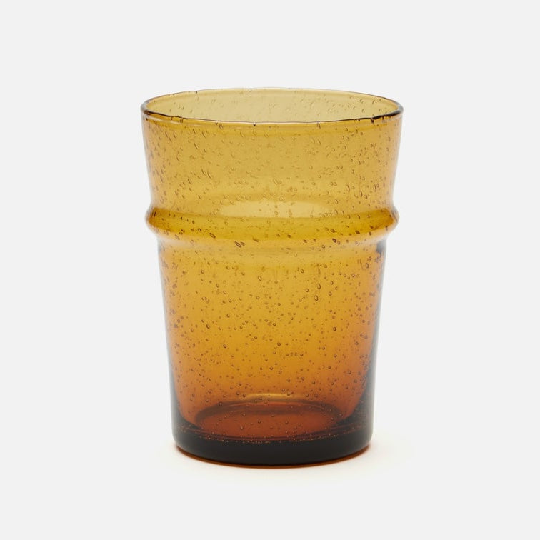 An amber-colored glass tumbler with a textured, speckled finish and a flared rim, shown on a clean white background.