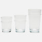Three clear textured glass tumblers of different heights arranged from smallest to largest on a light gray background.