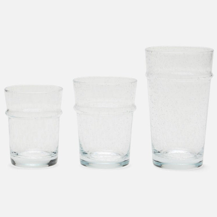 Three clear textured glass tumblers of different heights arranged from smallest to largest on a light gray background.