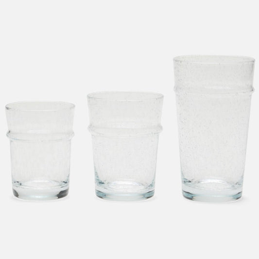 Three clear textured glass tumblers of different heights arranged from smallest to largest on a light gray background.