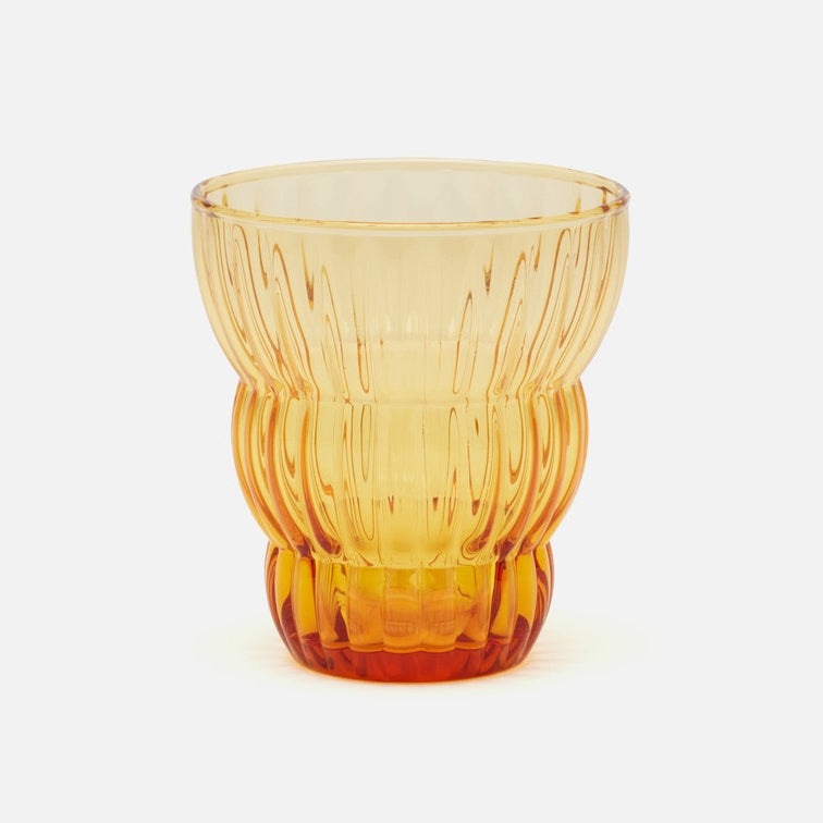 A translucent amber-colored glass tumbler with a ribbed, textured design, shown on a clean white background.
